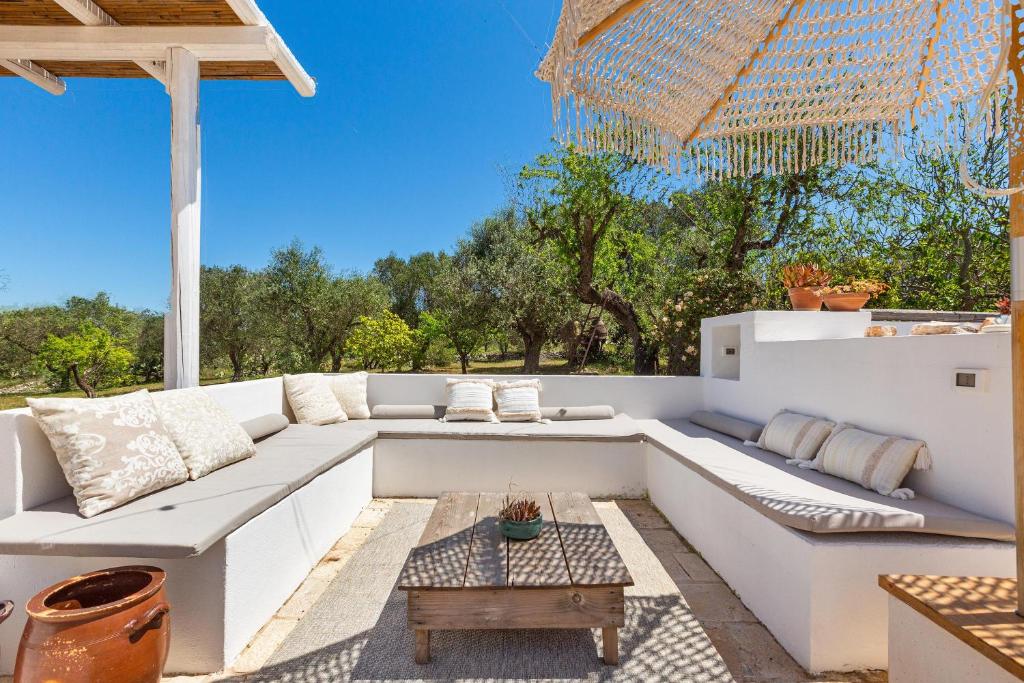 une terrasse avec un canapé blanc et une table dans l'établissement O` Trullo Mio by Perle di Puglia, à Ostuni