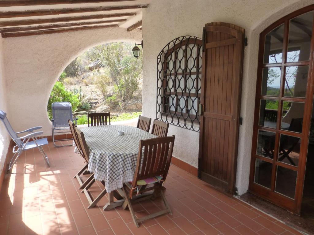 d'une terrasse avec une table, des chaises et une porte ouverte. dans l'établissement Villa Anna Maria, à Santa Margherita di Pula