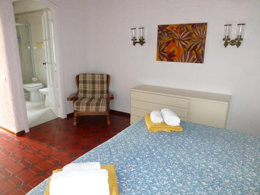 - une chambre avec un lit et une chaise ainsi qu'une salle de bains dans l'établissement Villa Anna Maria, à Santa Margherita di Pula