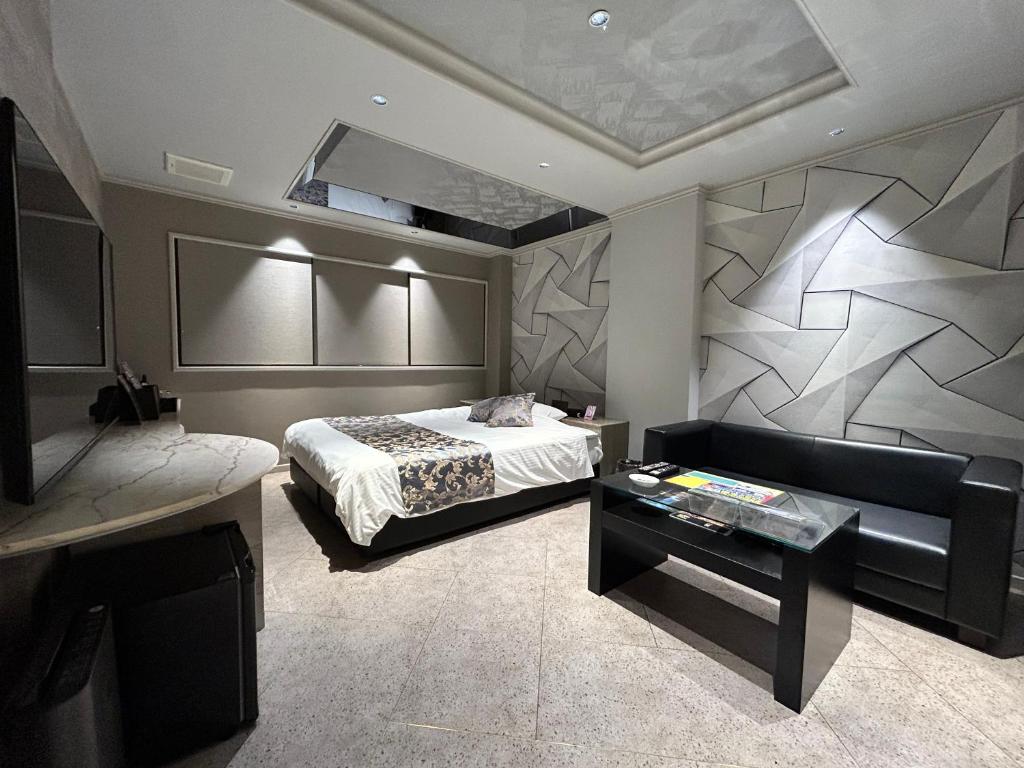 une chambre avec un lit, un canapé et une table dans l'établissement Hotel The Moon -Adult Only-, à Okayama 3 autres photos
