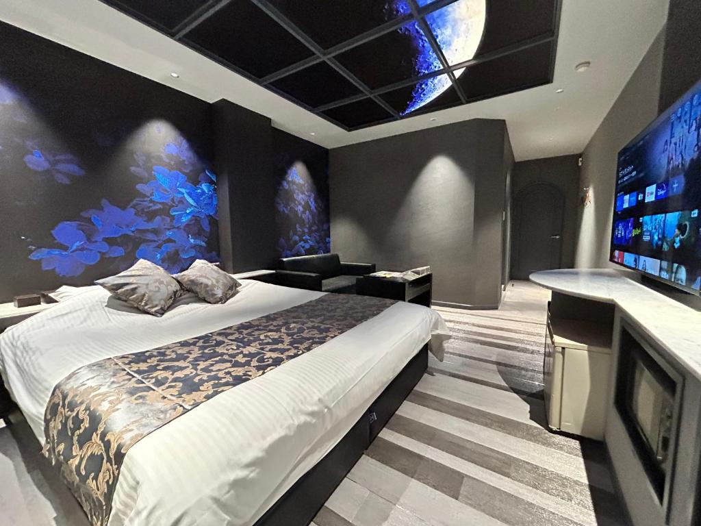 une chambre avec un grand lit et une télévision dans l'établissement Hotel The Moon -Adult Only-, à Okayama