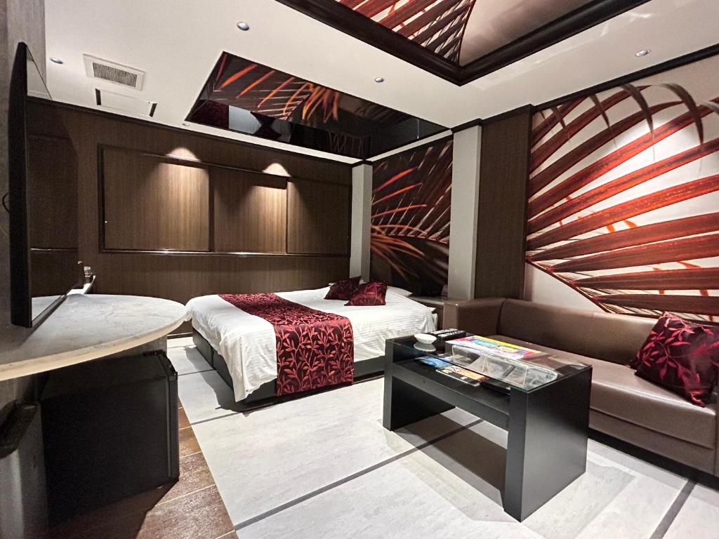 une chambre avec un lit et un canapé dans l'établissement Hotel The Moon -Adult Only-, à Okayama