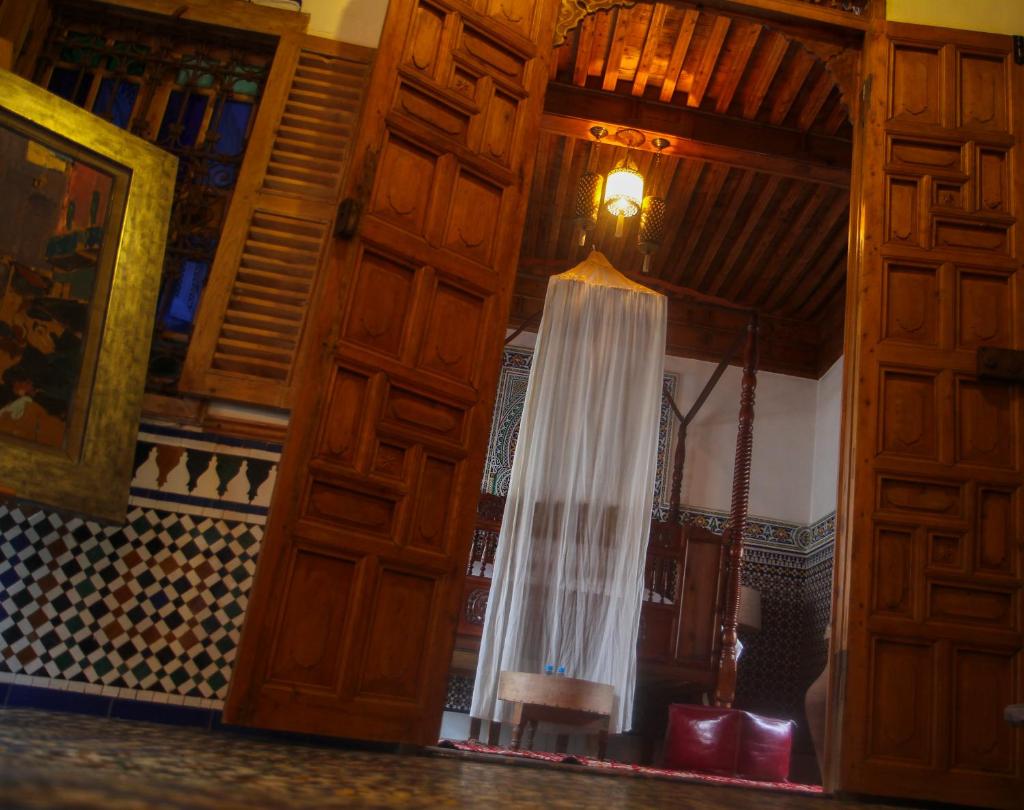 une porte en bois avec un rideau suspendu. dans l'établissement Dar Mayssane, à Rabat