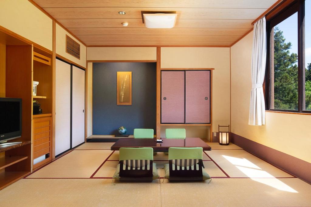 un salon avec une table et des chaises dans l'établissement Yamanaka Onsen Kagari Kisshotei, à Kaga