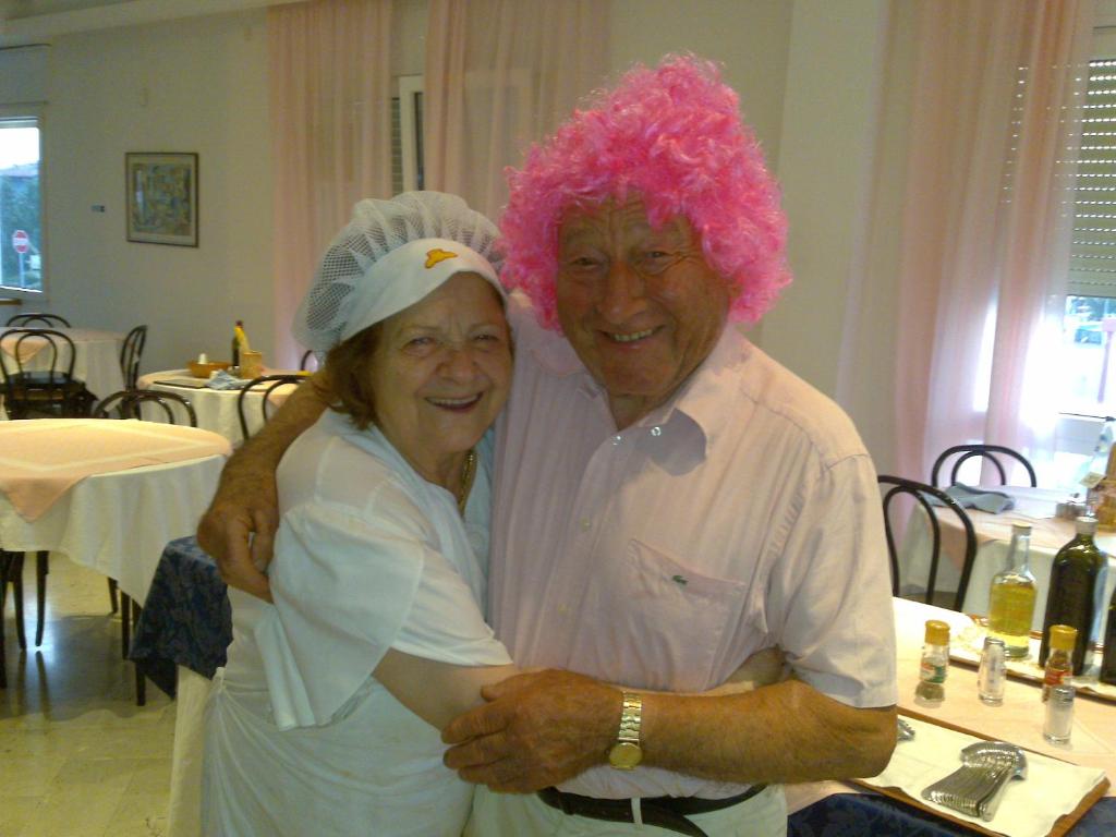 un homme et une femme aux cheveux roses posant une photo dans l'établissement Hotel Biagini, à Rimini