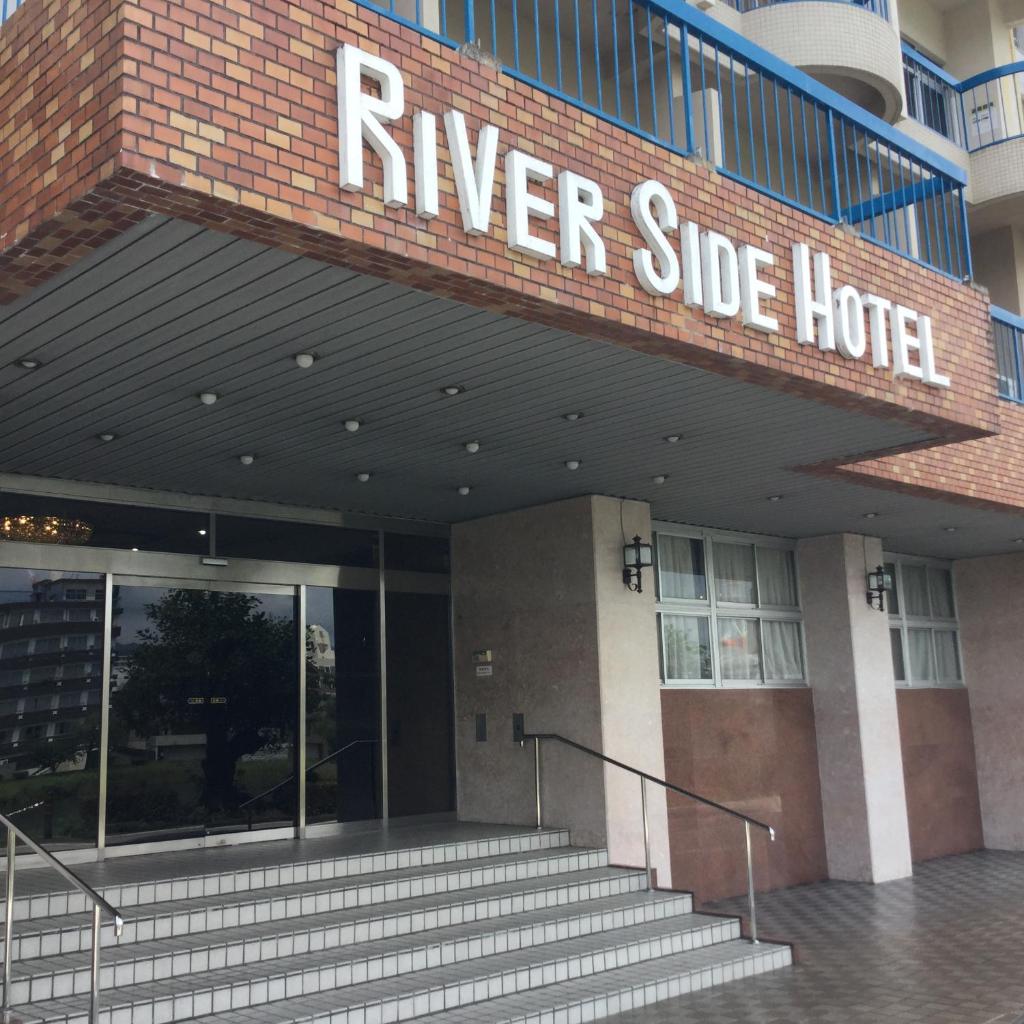 un bâtiment avec un panneau indiquant l'hôtel au bord de la rivière dans l'établissement Riverside Hotel Shoei, à Kōchi