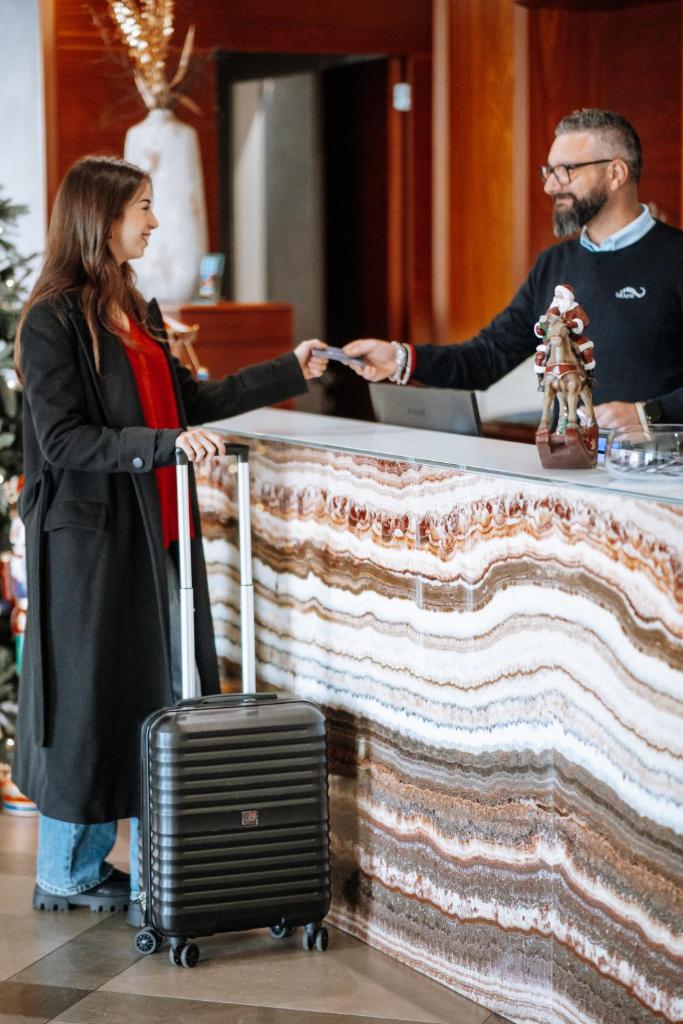 un homme et une femme se serrant la main à un comptoir dans l'établissement Le Dune Suite Hotel, à Porto Cesareo 50 autres photos
