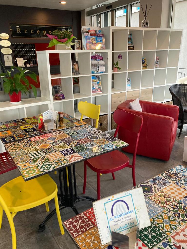 un magasin avec des tables, des chaises et des étagères colorées dans l'établissement Hotel Panorama, à Lido di Jesolo