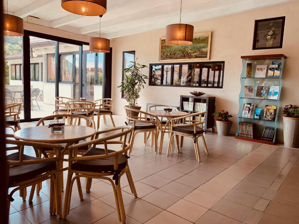 une salle à manger avec tables, chaises et fenêtres dans l'établissement River Park Hotel, à Ameglia