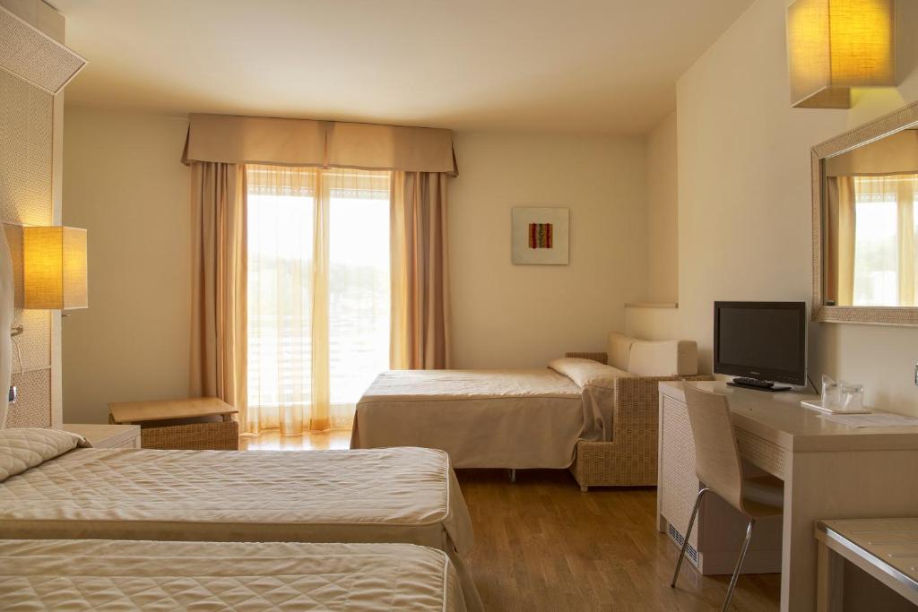 une chambre d'hôtel avec deux lits et un bureau dans l'établissement Hotel Mara, à Ortona 124 autres photos