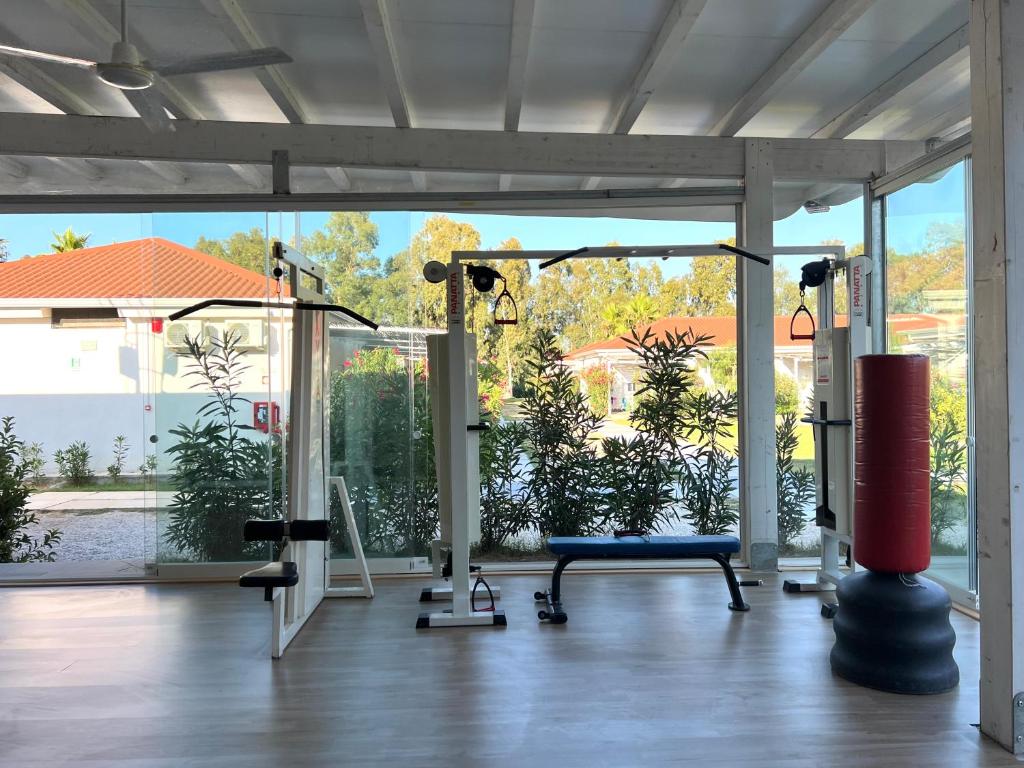 - une salle de sport avec vue sur la piscine dans l'établissement Resort Acqua di Venere, à Paestum