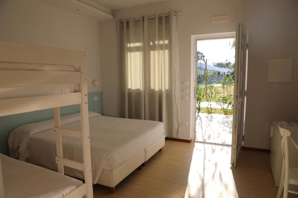 - une chambre avec 2 lits superposés et une porte coulissante en verre dans l'établissement Resort Acqua di Venere, à Paestum
