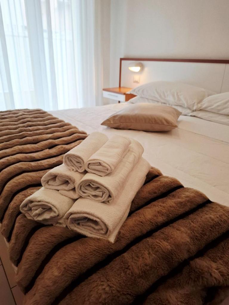 une pile de serviettes sur un lit dans l'établissement Hotel Brotas, à Rimini