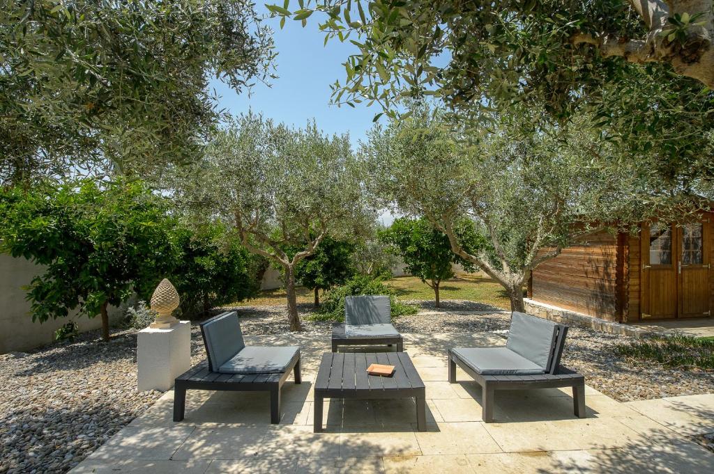 un patio avec trois chaises et une table et une table et deux chaises dans l'établissement Tenuta con due abitazioni indipendenti, à Martina Franca