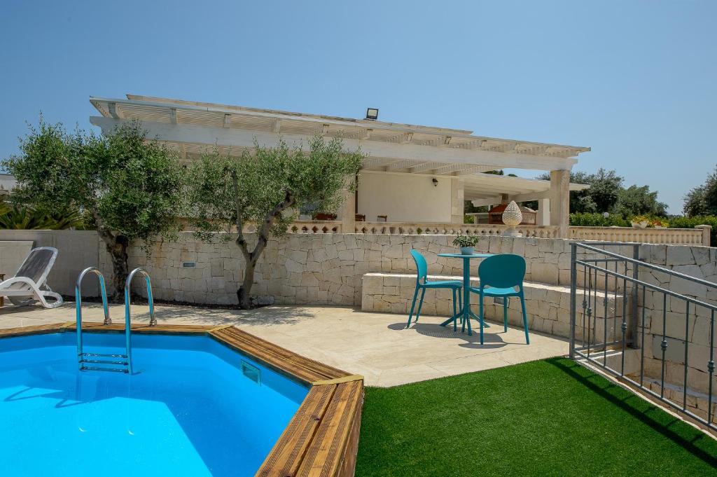 une cour avec une piscine, une table et des chaises dans l'établissement Tenuta con due abitazioni indipendenti, à Martina Franca