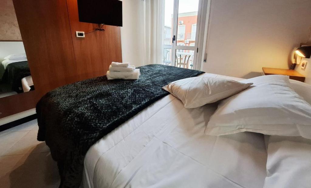 une chambre avec un lit avec deux serviettes dessus dans l'établissement Hotel Brotas, à Rimini 25 autres photos