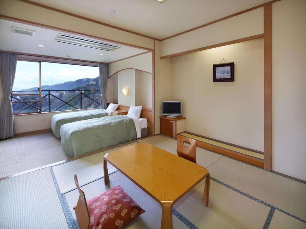 une chambre d'hôtel avec un lit, une table et une fenêtre dans l'établissement Hakonenomori Okada, à Hakone 37 autres photos
