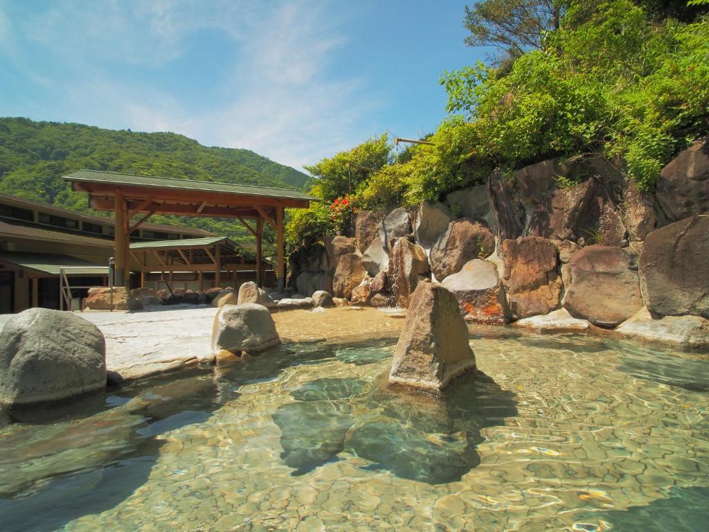 un bassin d'eau avec quelques rochers dans l'établissement Hakonenomori Okada, à Hakone