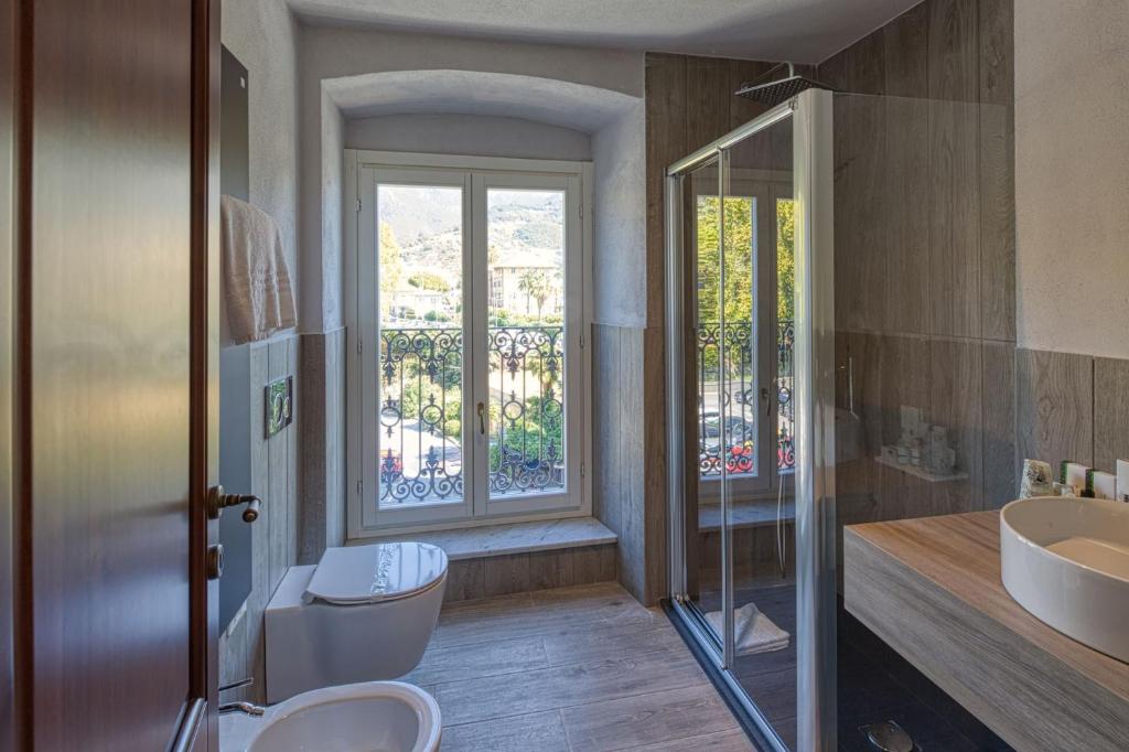 une salle de bain avec toilettes, lavabo et fenêtre dans l'établissement Residence Via Di Francia, à Arenzano