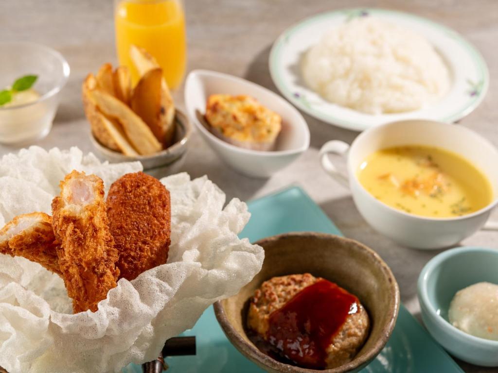 - une table avec des assiettes de nourriture et des bols de soupe dans l'établissement Izumigo Takayama Dog Paradise Hotel, à Takayama