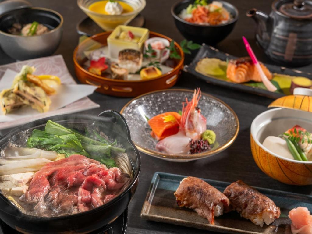une table recouverte de assiettes et de bols de nourriture dans l'établissement Izumigo Takayama Dog Paradise Hotel, à Takayama