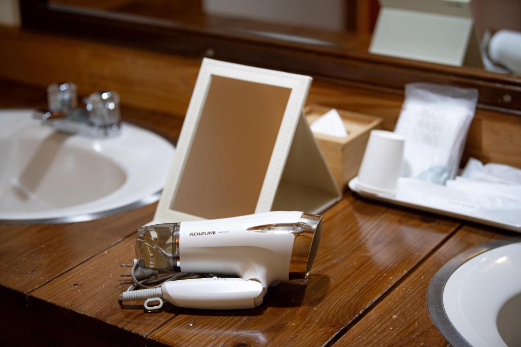un sèche-cheveux assis au-dessus d'une table en bois dans l'établissement 山荘 紗羅樹 Syaranoki, à Yufu