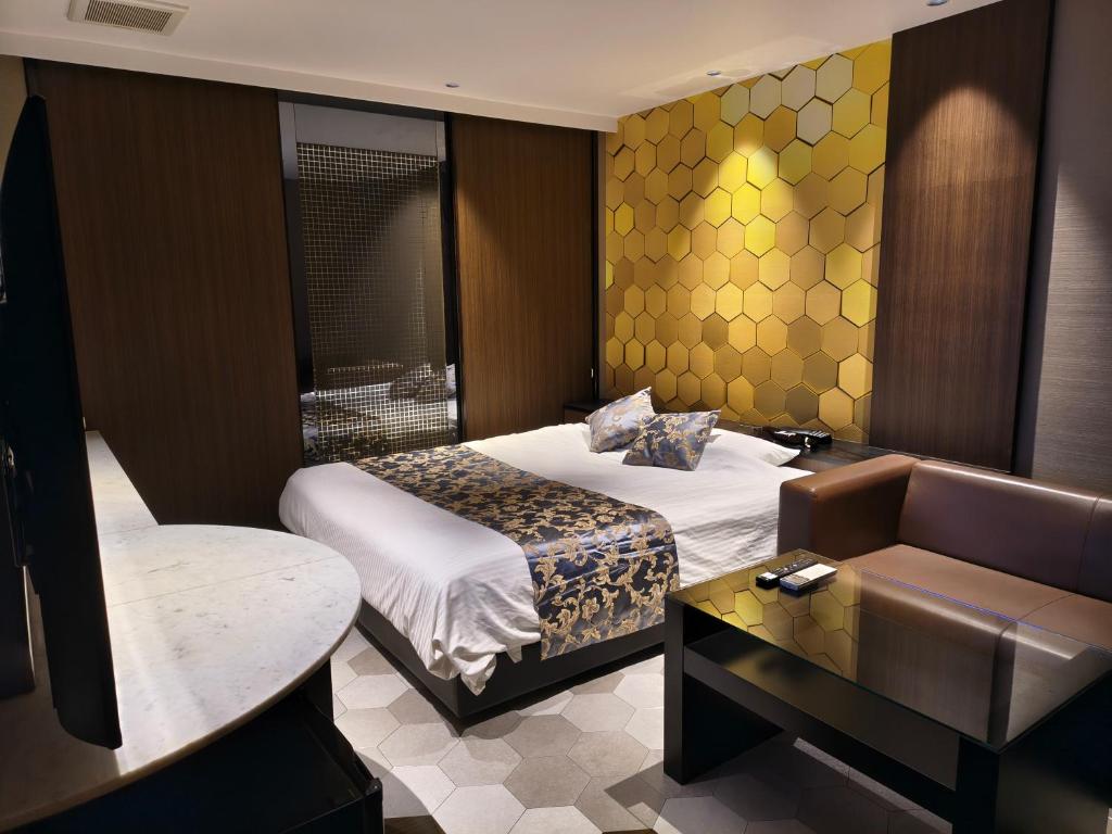 une chambre d'hôtel avec deux lits et un canapé dans l'établissement Hotel The Moon -Adult Only-, à Okayama