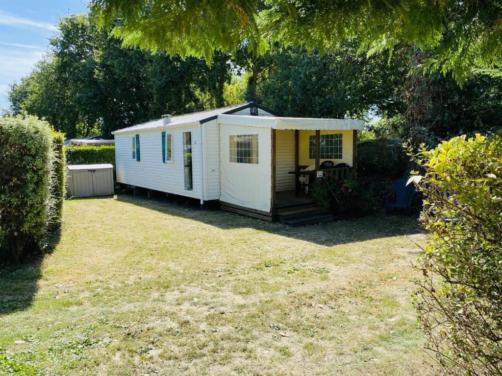 un hangar blanc et jaune dans une cour dans l'établissement Carnac - Mobil Home - 5 pers - 2 ch - Camping Moulin de Kermaux 4* - Piscine, à Carnac