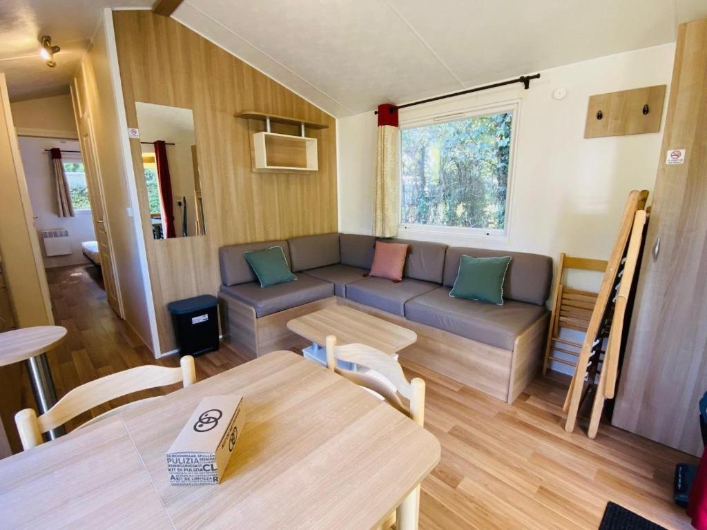 un salon avec un canapé et une table dans l'établissement Carnac - Mobil Home - 5 pers - 2 ch - Camping Moulin de Kermaux 4* - Piscine, à Carnac