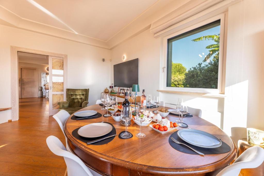 une salle à manger avec une table en bois et une fenêtre dans l'établissement Villa Modigliani, à Casarano