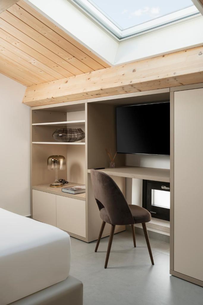 - une chambre avec un lit, une chaise et une télévision dans l'établissement BOMA Prime Rooms, à Civitanova Marche