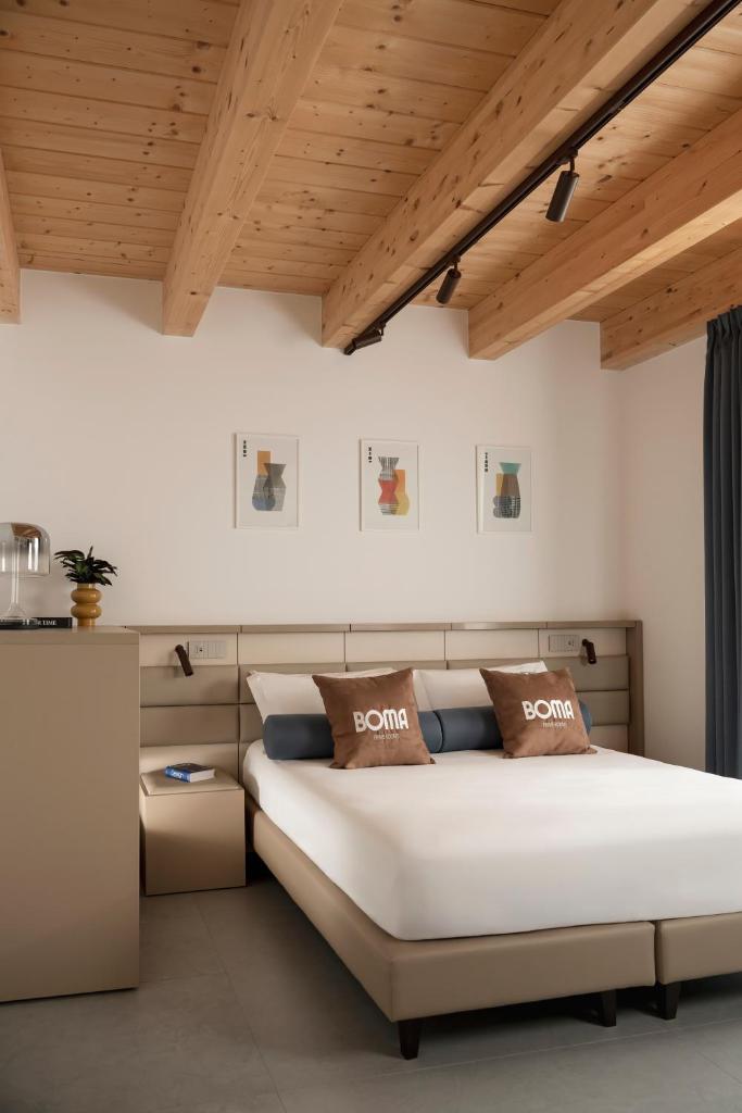 - une chambre avec un grand lit et des plafonds en bois dans l'établissement BOMA Prime Rooms, à Civitanova Marche