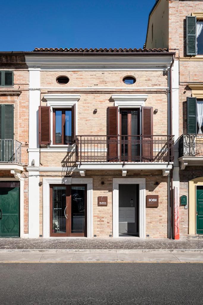 - un grand bâtiment en briques avec des balcons dans une rue dans l'établissement BOMA Prime Rooms, à Civitanova Marche