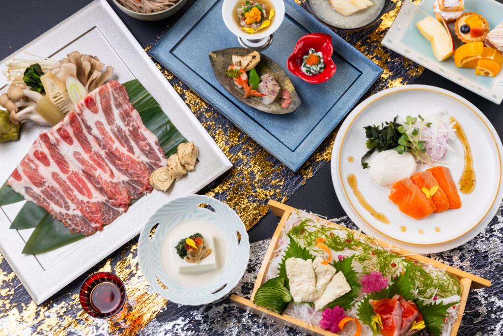 une table sur laquelle sont posées des assiettes remplies de nourriture dans l'établissement Kyukamura Nikko-Yumoto, à Nikkō