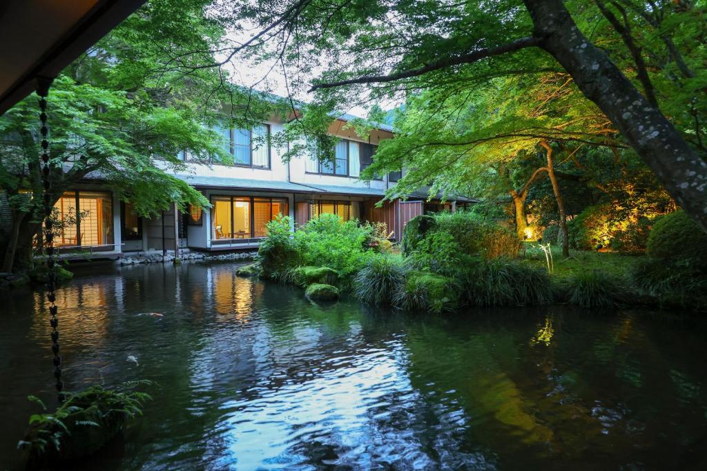 une maison avec une rivière devant elle dans l'établissement Oku Yugawara Tsubaki, à Yugawara
