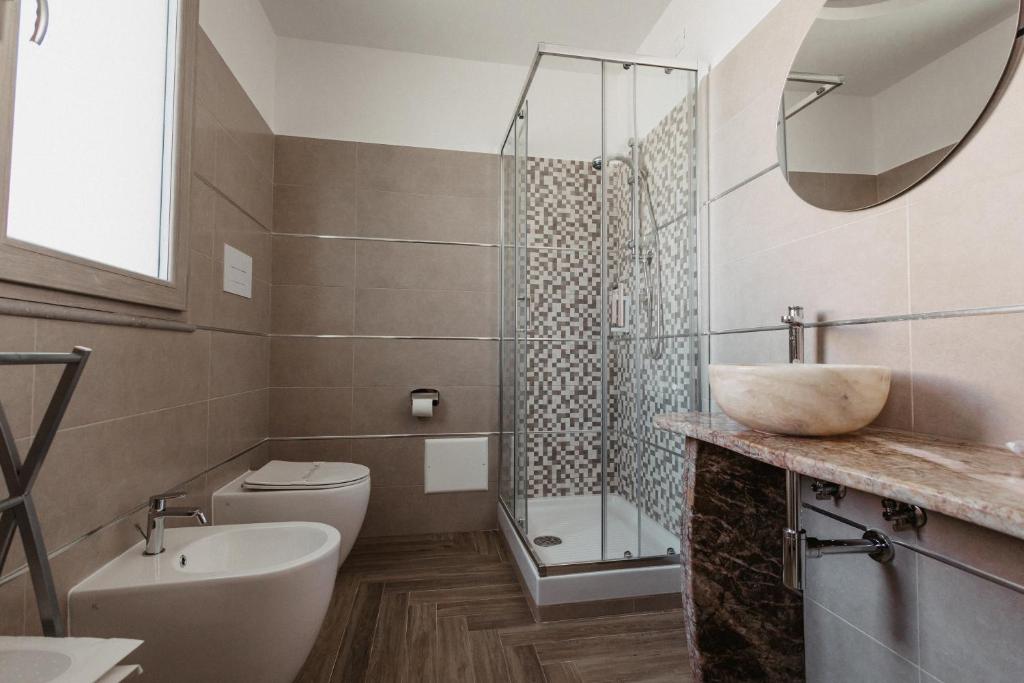 une salle de bain avec un lavabo, des toilettes et une douche dans l'établissement Hotel Chiaro di Luna, à Marina di Ascea