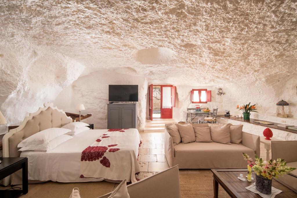 une chambre avec un lit et un salon dans l'établissement Masseria Torre Coccaro, à Savelletri di Fasano