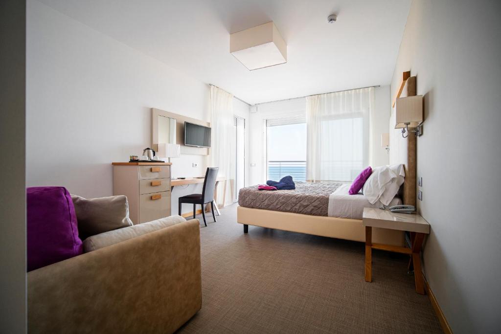une chambre d'hôtel avec un lit et un canapé dans l'établissement Hotel Le Soleil, à Lido di Jesolo