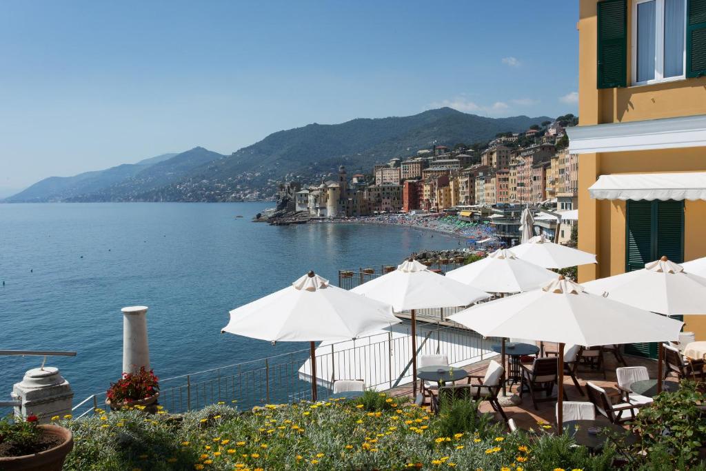 un groupe de parapluies blancs et une masse d'eau dans l'établissement Hotel Cenobio Dei Dogi, à Camogli