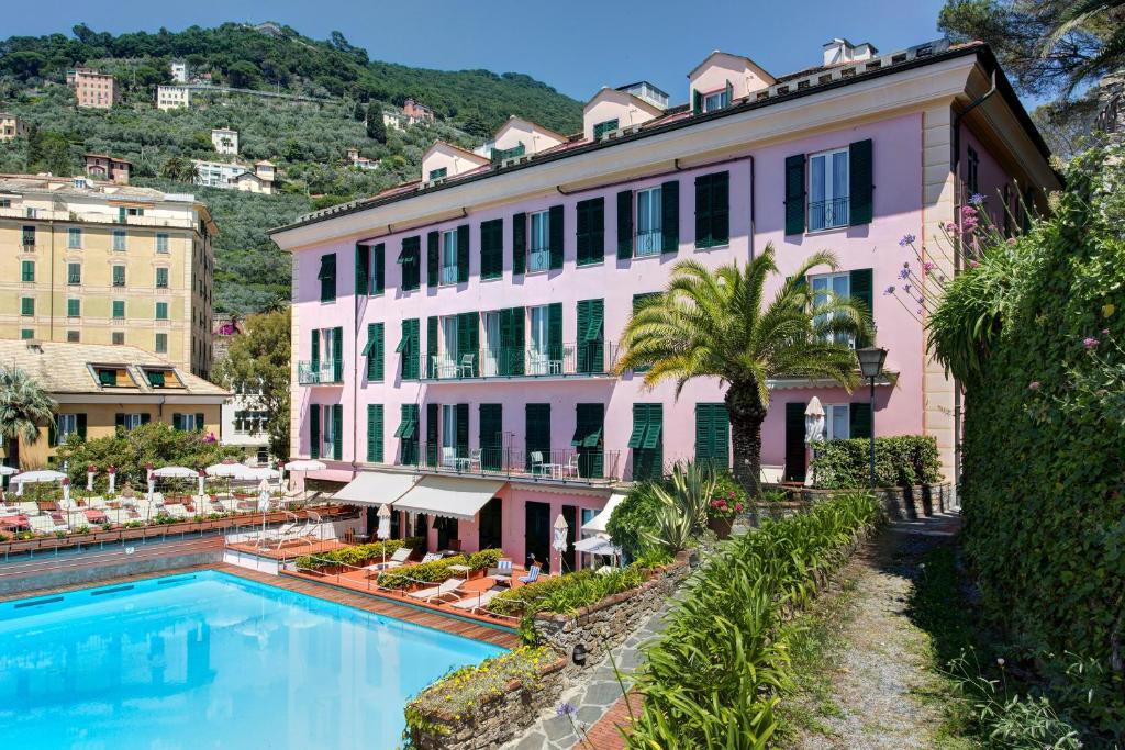un hôtel avec une piscine devant un bâtiment dans l'établissement Hotel Cenobio Dei Dogi, à Camogli