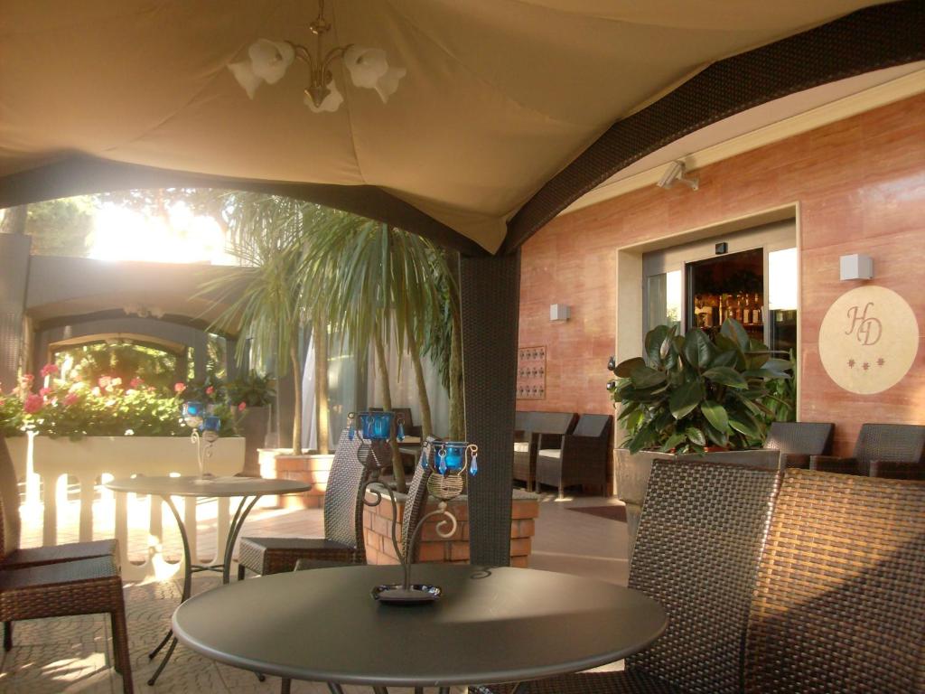 un restaurant avec des tables et des chaises et une terrasse dans l'établissement Hotel Donatella Pinarella, à Cervia
