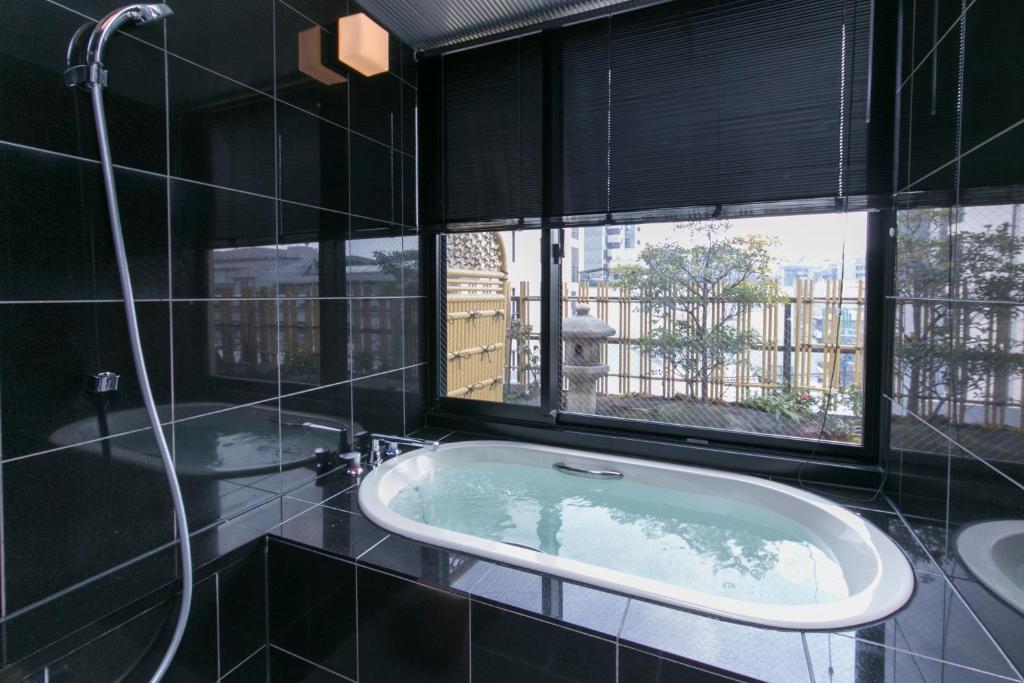 une baignoire dans une salle de bain avec une fenêtre dans l'établissement Matsui-Bekkan Hanakanzashi, à Kyoto