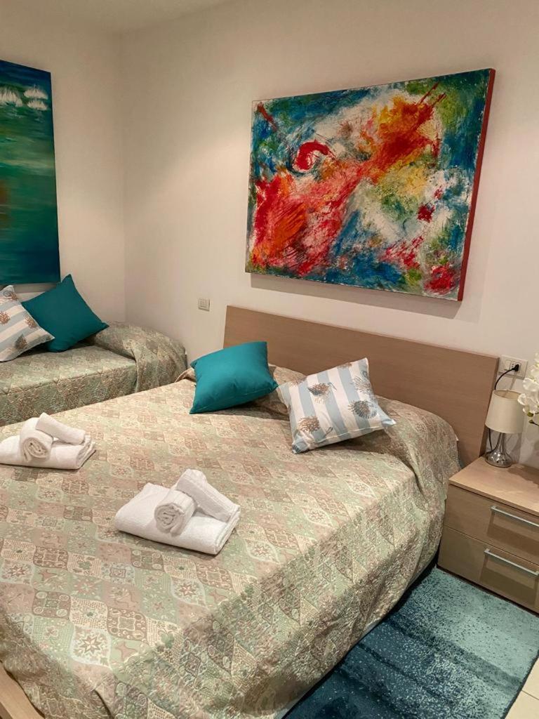 deux lits dans une chambre avec un tableau au mur dans l'établissement Villa Gentile, à Cavallino-Treporti