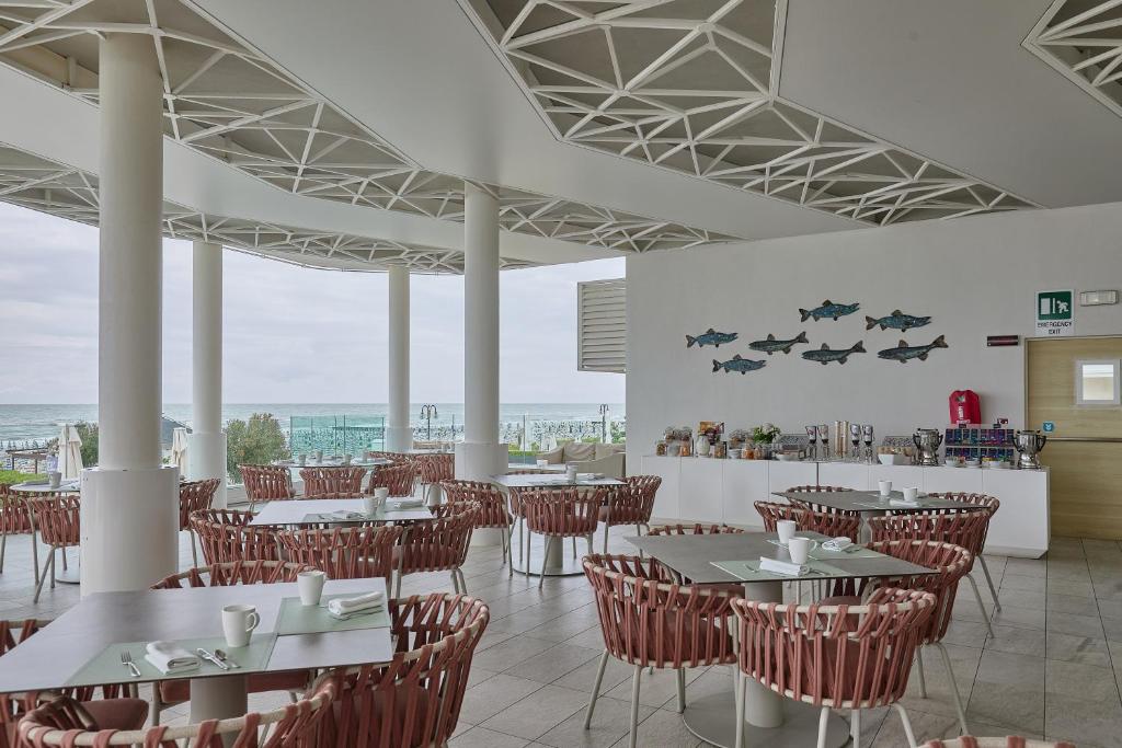 un restaurant avec des tables, des chaises et un comptoir dans l'établissement Hotel Le Soleil, à Lido di Jesolo