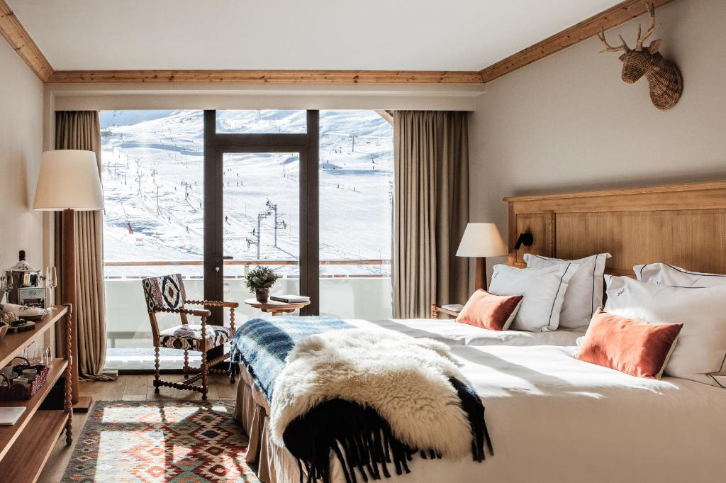 une chambre avec un lit et une grande fenêtre dans l'établissement Alpes Hôtel du Pralong, à Courchevel 78 autres photos