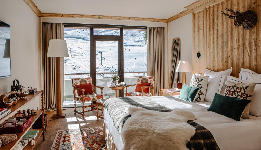 - une chambre avec un lit et une vue sur la montagne dans l'établissement Alpes Hôtel du Pralong, à Courchevel