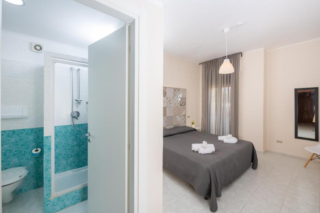 une chambre avec un lit et une salle de bain avec douche dans l'établissement Hotel Club Eloro, à Noto Marina