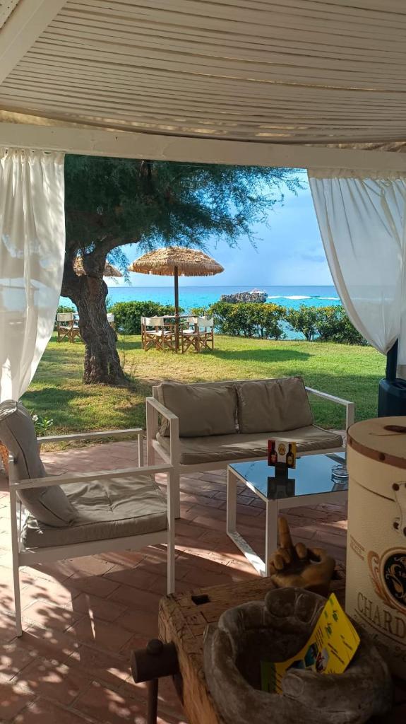 - un salon avec un canapé et un parasol dans l'établissement Borgo di Riaci Beach Resort, à Santa Domenica