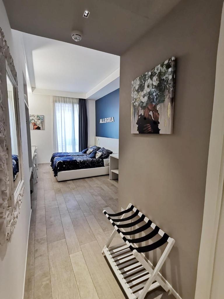 un salon avec un lit et un canapé dans l'établissement Hotel Madalù, à Rimini