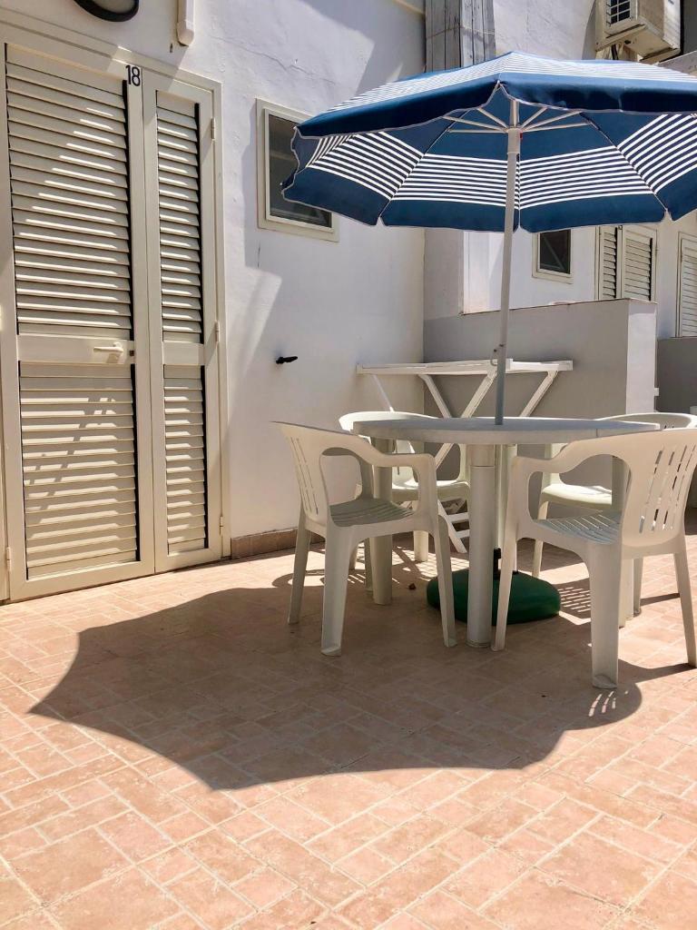 une table et des chaises avec un parasol sur une terrasse dans l'établissement Tiglio Vieste, à Vieste